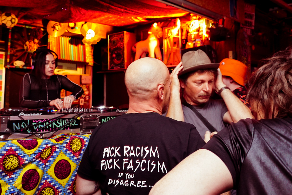 Dj and dancers, a teeshirt reads fuck racism fuck fascism